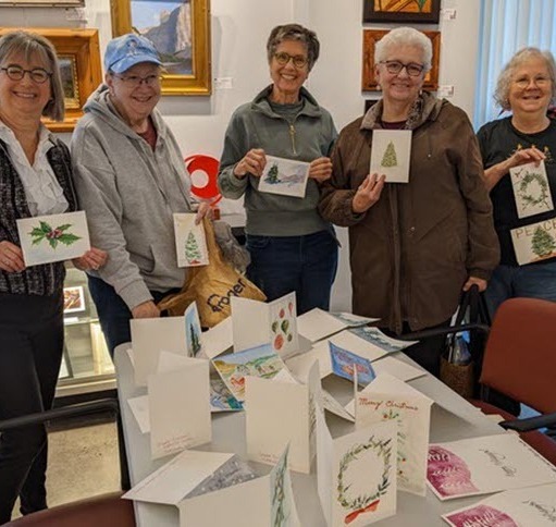 Smiling group holding hand-painted holiday cards